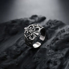 Silver ring with intricate design on a textured surface