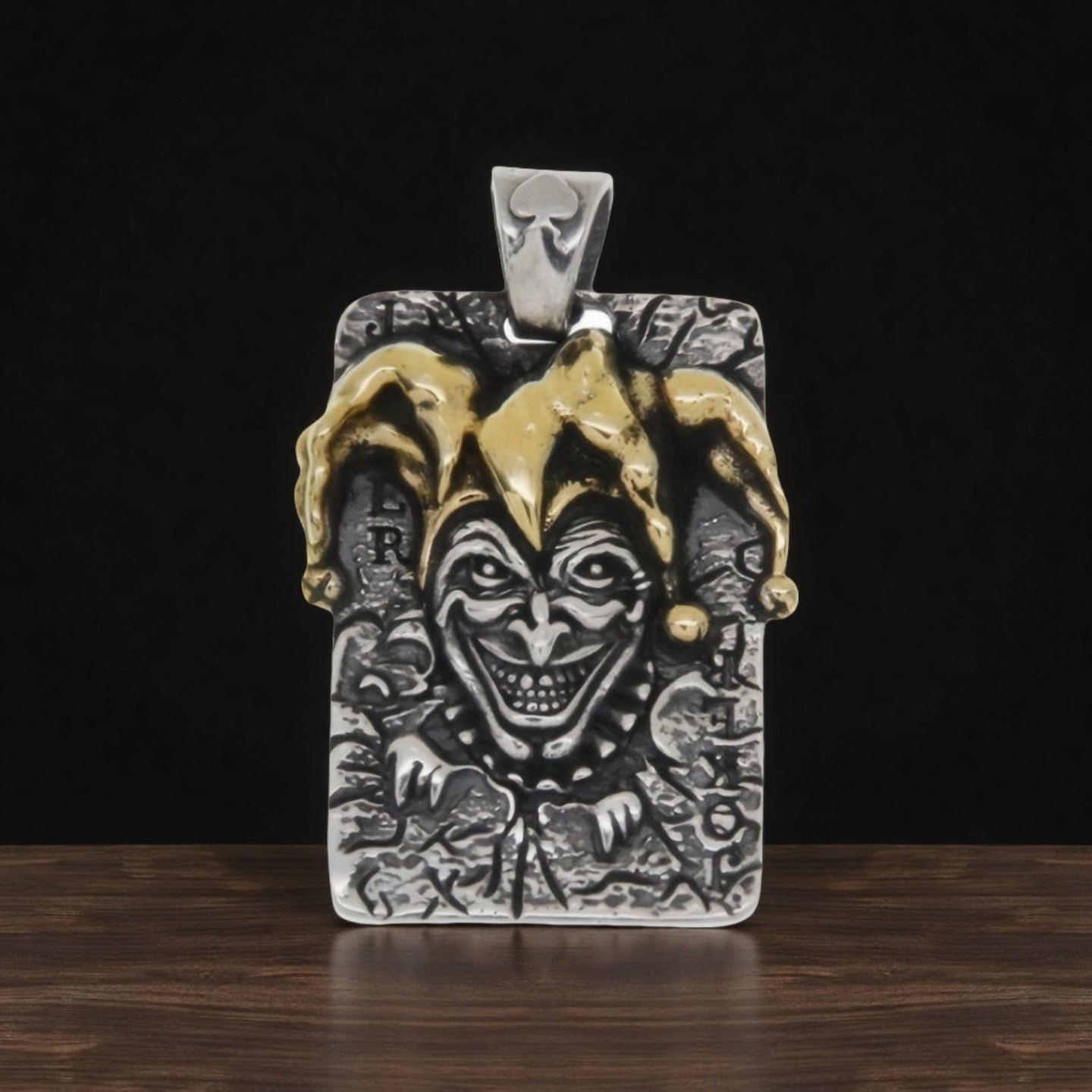 Joker-themed pendant with gold and silver accents on a dark background