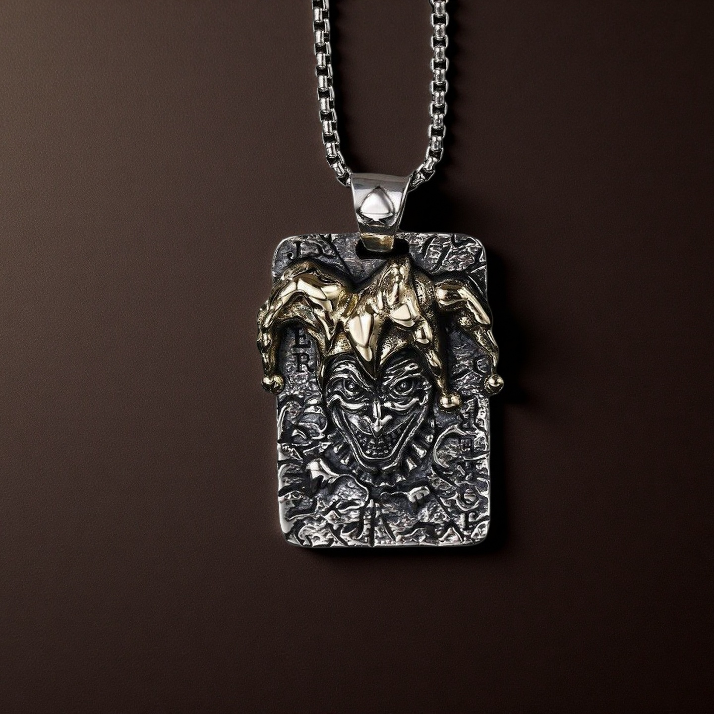 Silver pendant with a face design on a brown background
