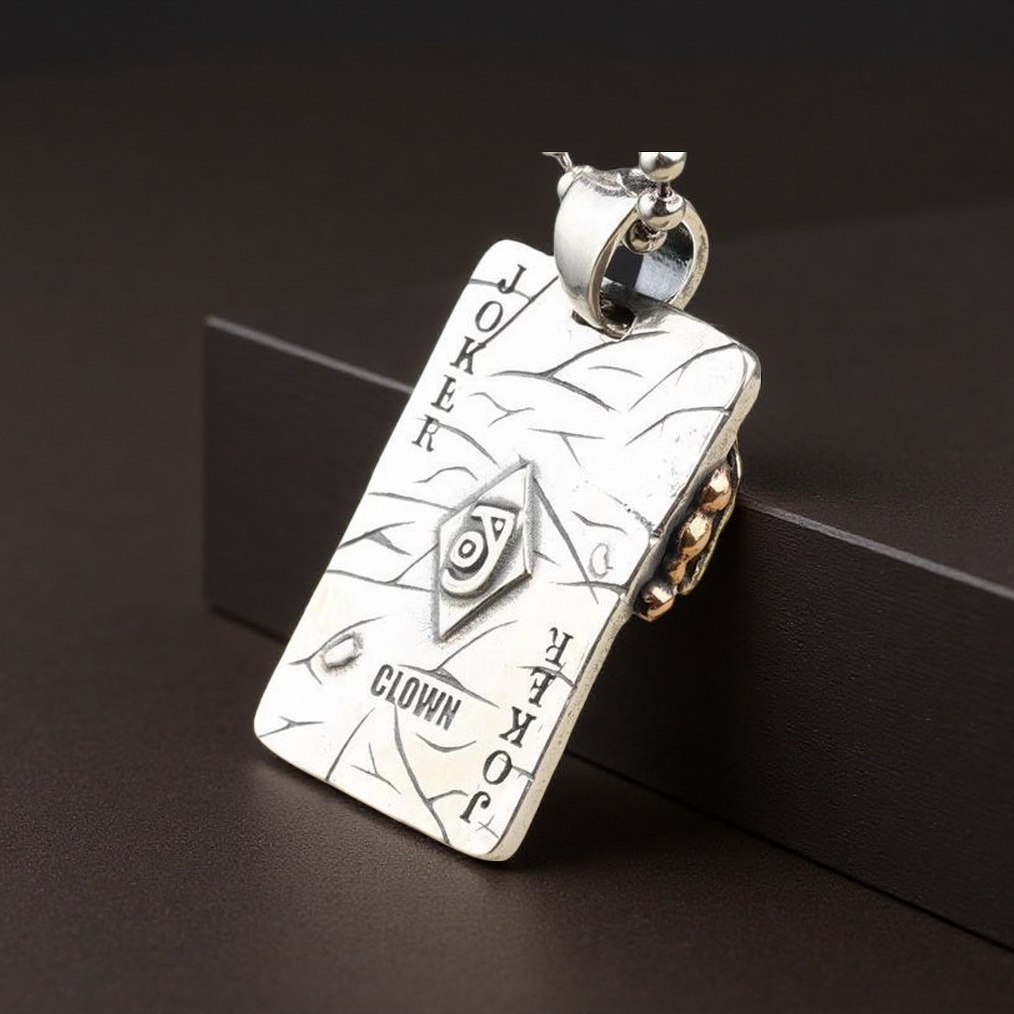 Silver pendant with intricate designs on a dark background