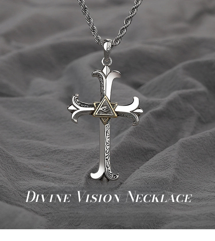 Silver cross necklace with intricate design on a gray fabric background