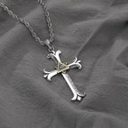 Silver cross pendant necklace on a gray fabric background