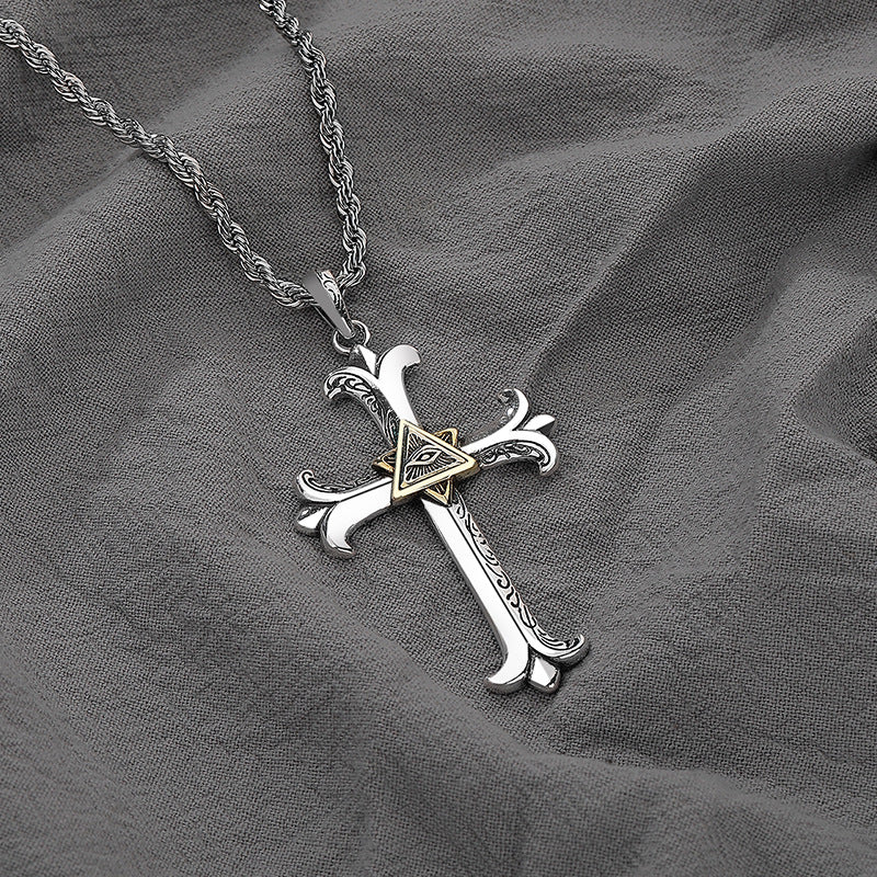 Silver cross pendant necklace on a gray fabric background