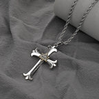 Silver cross necklace with a gold triangle pendant on a gray fabric background