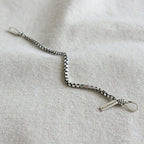 Silver bracelet on a light fabric background