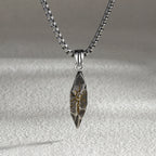 Silver pendant necklace on a textured gray background