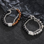 Two beaded bracelets on a textured black surface