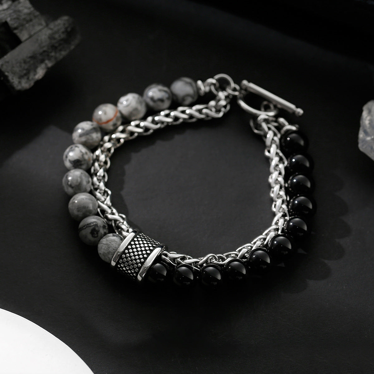 Bracelet with beads and chain on a dark surface