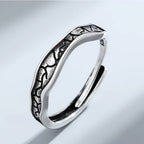 Silver ring with intricate design on a light gray background