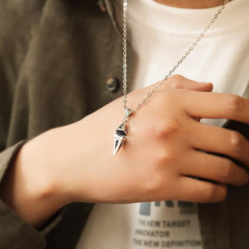 Person wearing a silver necklace with a unique pendant