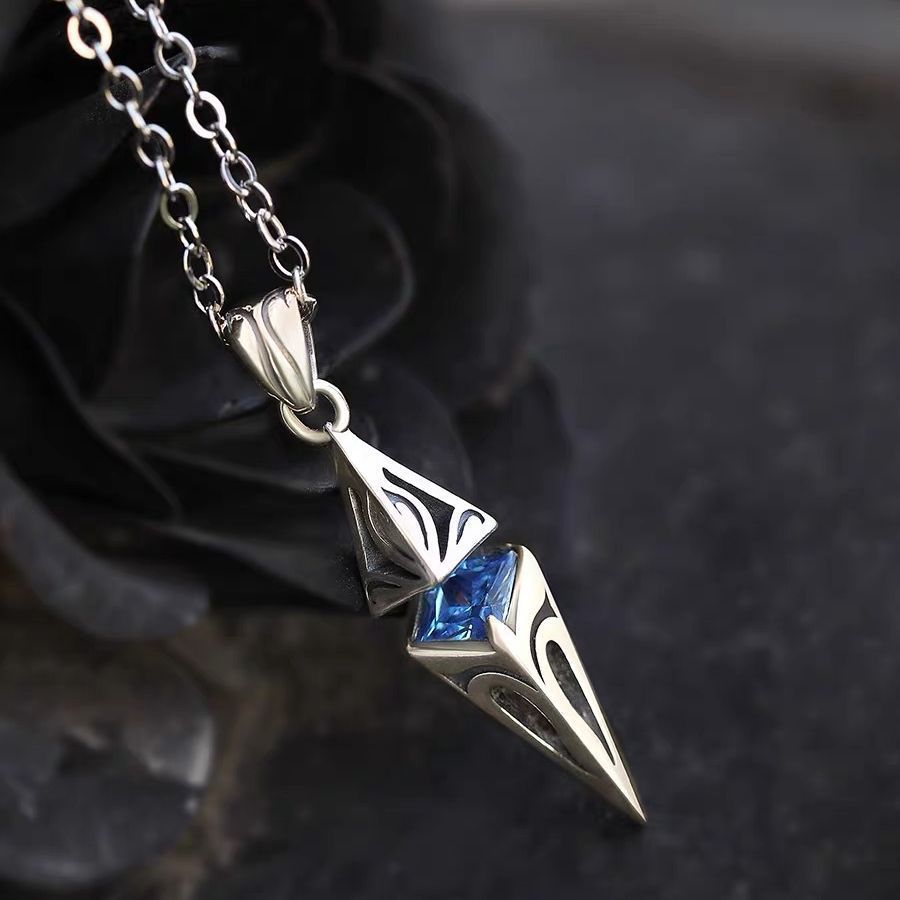 Silver pendant with blue gemstone on a dark background