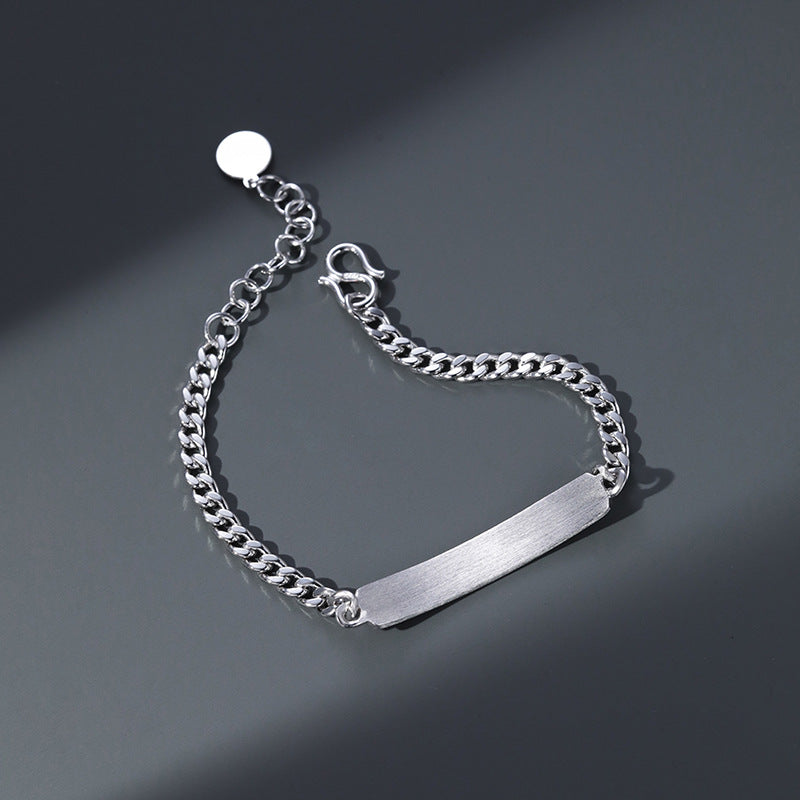 Silver chain bracelet with a bar clasp on a dark gray background