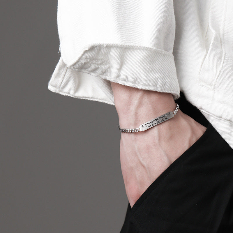 Silver bracelet on a wrist with a gray background
