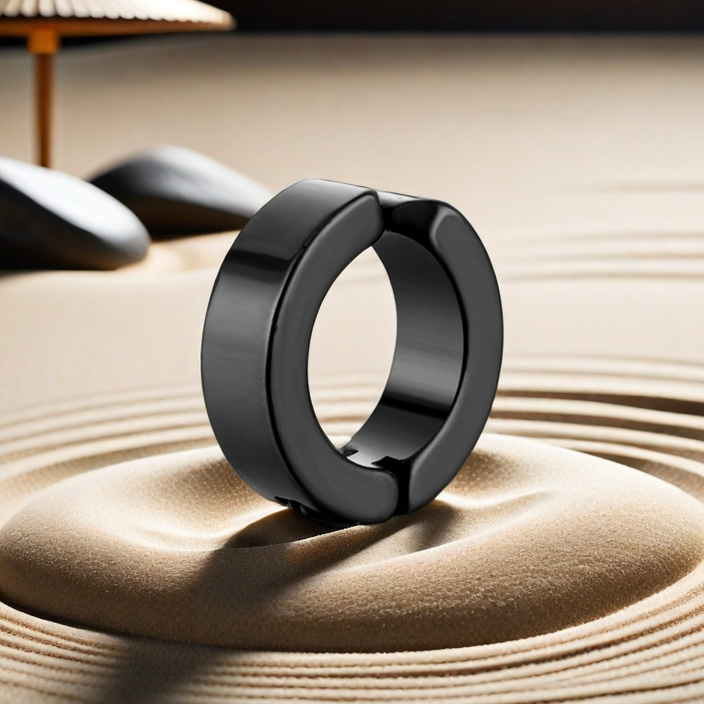 Black ring on a textured sand surface