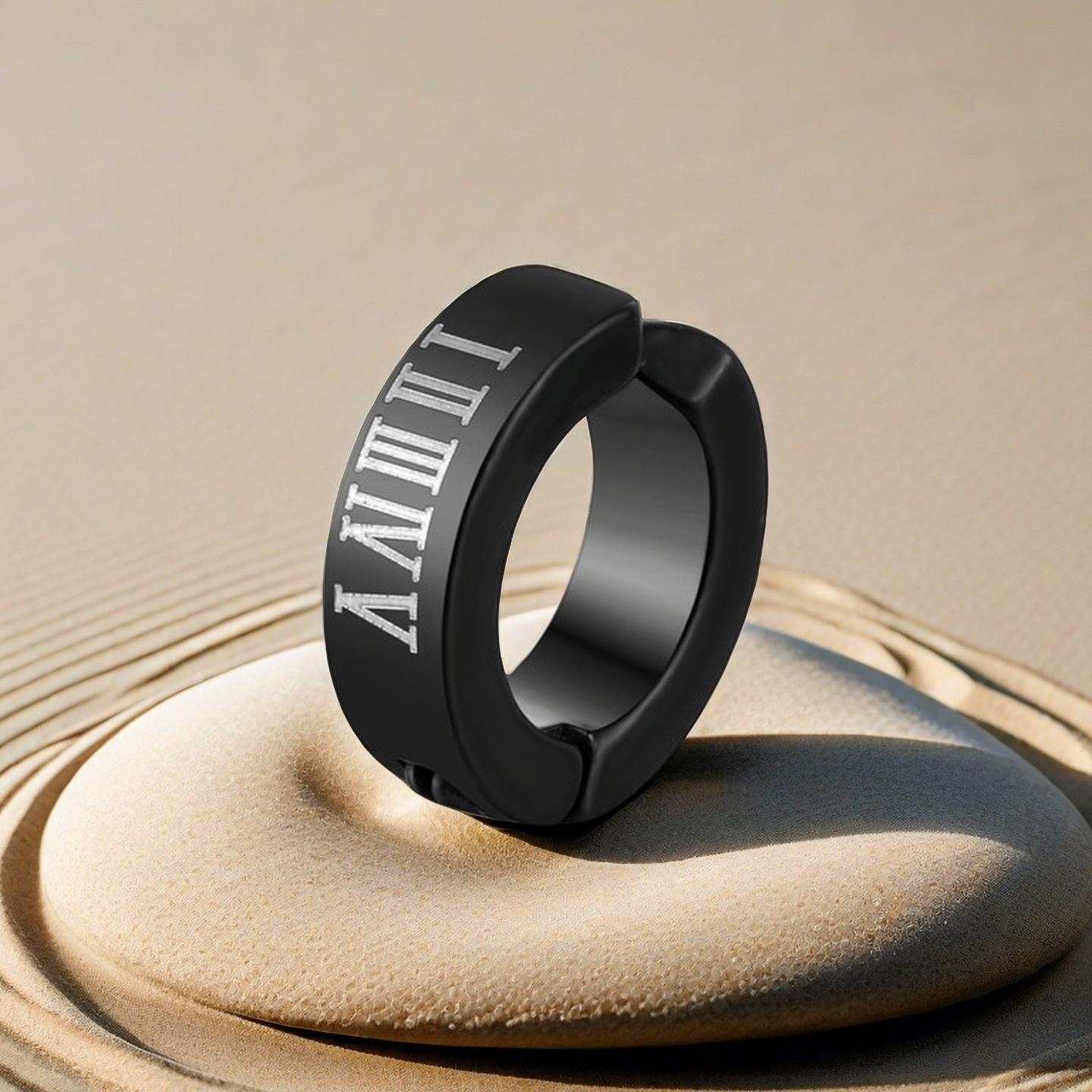 Black ring with Roman numeral engraving on a sandstone surface