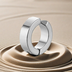 Silver ring on a textured beige surface