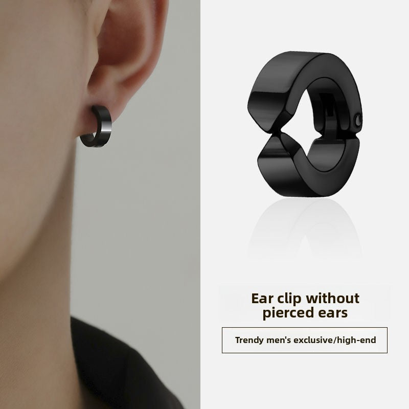 Black ear clip worn on an ear with a plain background