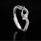 Silver ring with a textured design on a black background