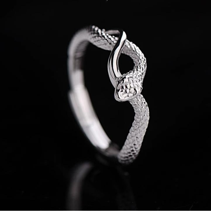 Silver ring with a textured design on a black background