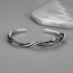 Silver braided bracelet on a gray background
