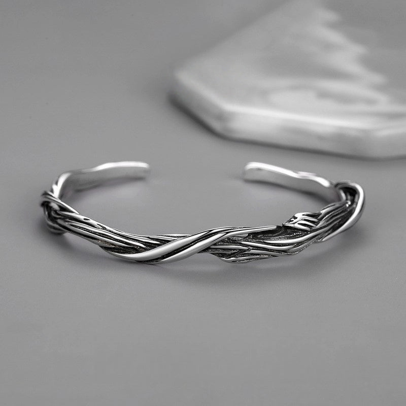 Silver braided bracelet on a gray background