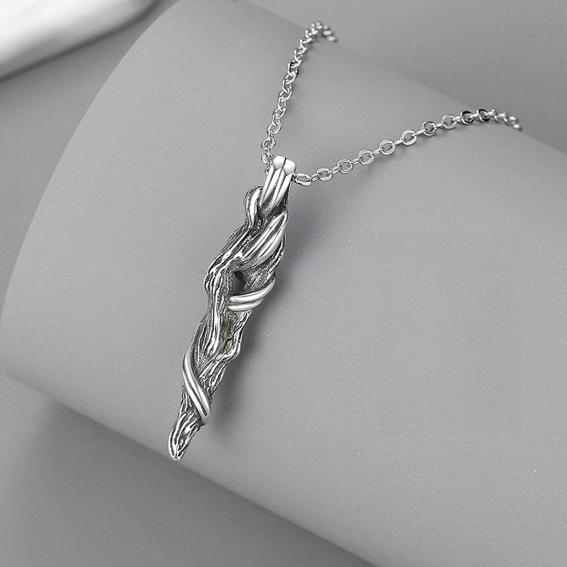 Silver wing-shaped pendant on a chain against a gray background