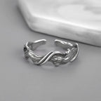 Silver twisted ring on a gray surface