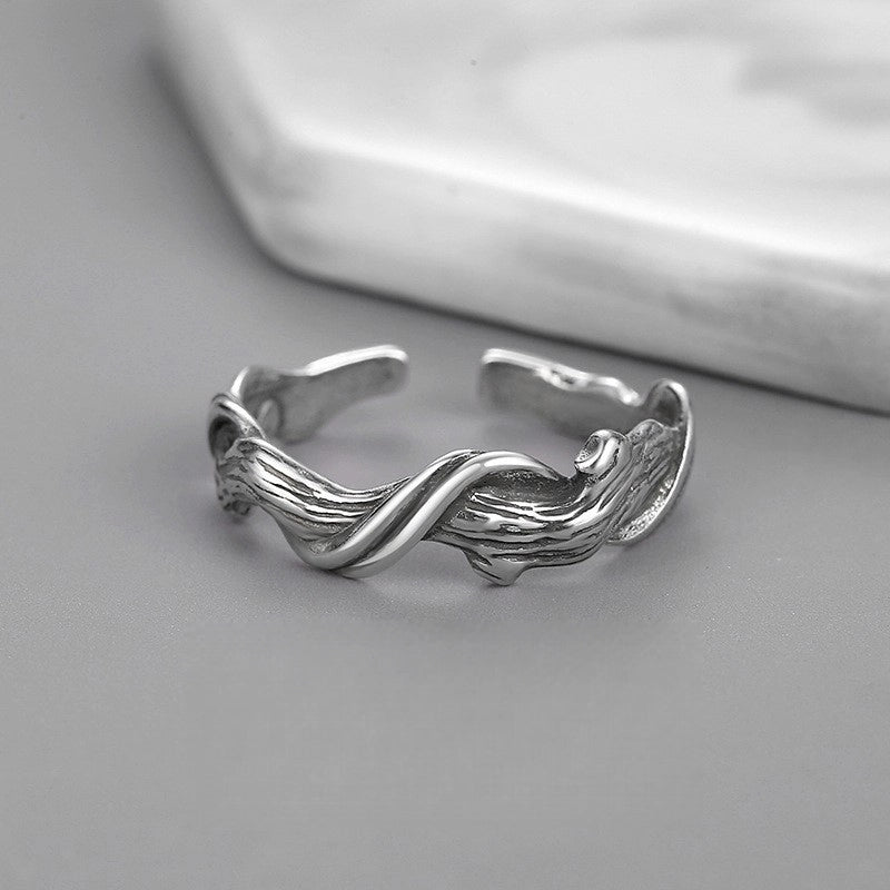 Silver twisted ring on a gray surface